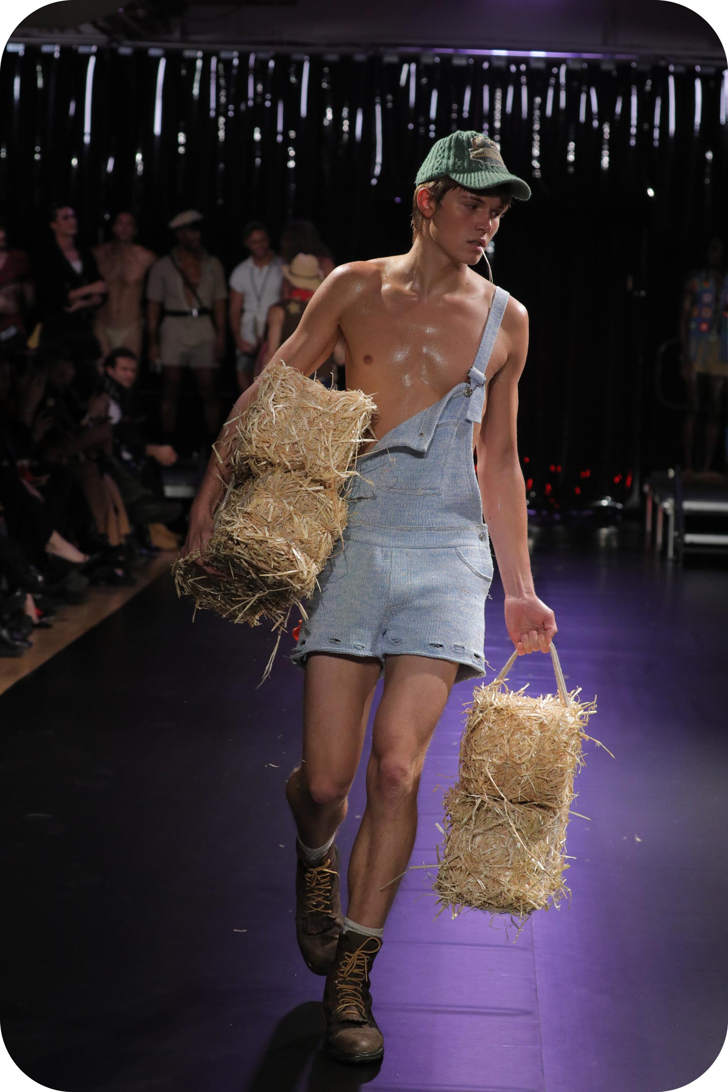 A man wearing a short blue farmer onesie made of gay wool